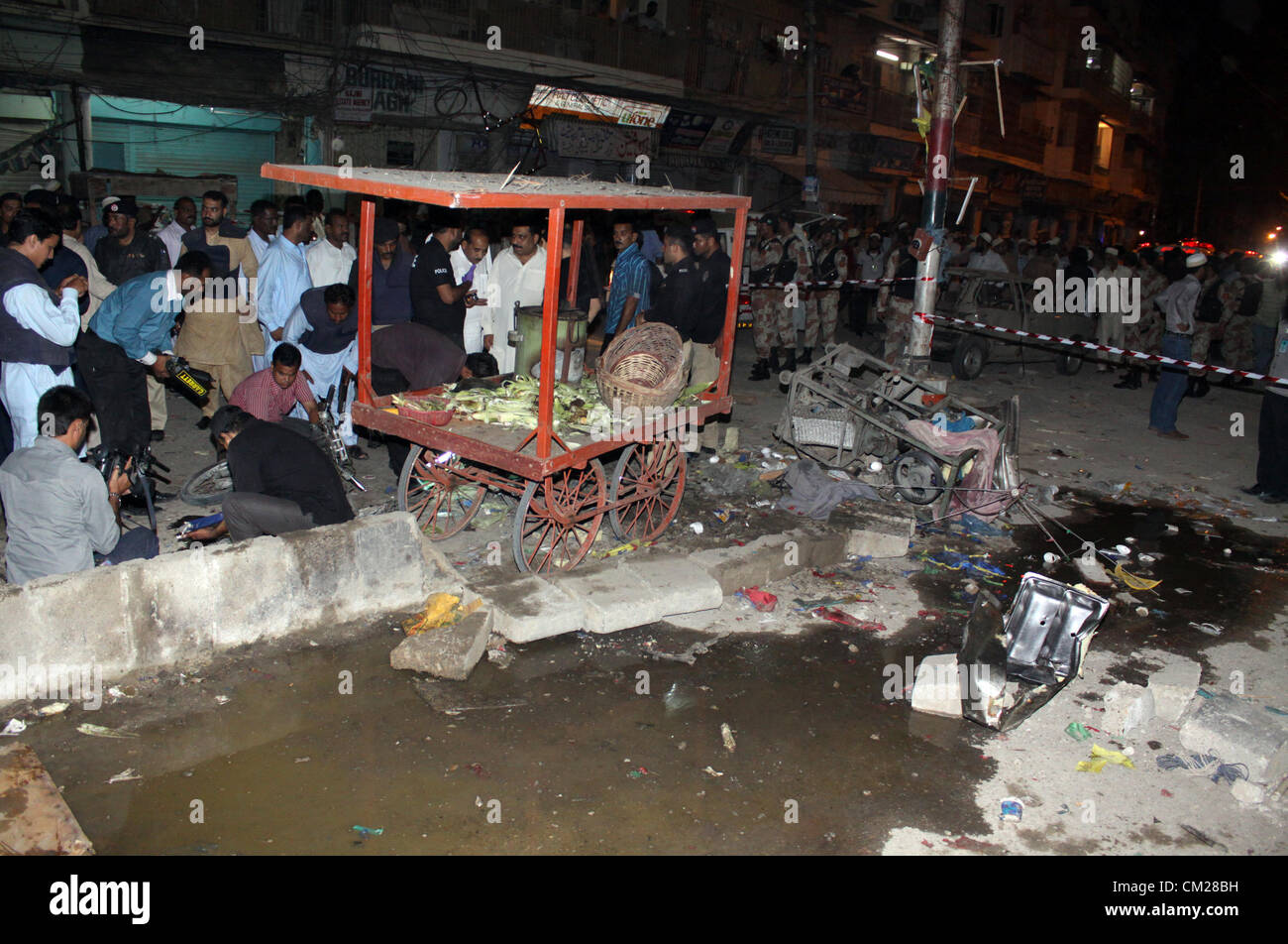 Karachi, Pakistan. 18 septembre, 2012. Les responsables de la police d'examiner le site d'une explosion près de la résidence des musulmans bohri et centre communautaire à Karachi le 18 septembre 2012. au moins 8 personnes ont été tuées et plusieurs autres ont été blessés lorsque plantés deux bombes ont explosé. Banque D'Images