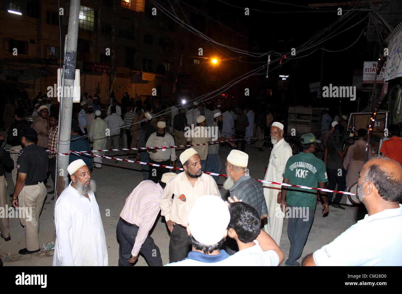 Les participants sont réunis sur le site d'une explosion près de la résidence des musulmans Bohri et centre communautaire à Karachi le 18 septembre 2012. Au moins 8 personnes ont été tuées et plusieurs autres ont été blessés lorsque plantés deux bombes ont explosé. Banque D'Images