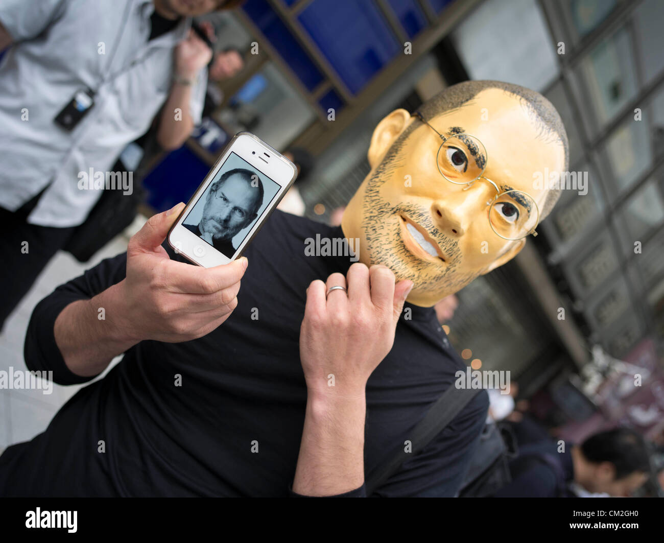 Le Japon, Tokyo. 21 septembre 2012. Fan d'Apple japonais portant masque et Steve Jobs en tenant son iPhone 4 en attente à l'extérieur de la ligne de l'Apple Store de Ginza de Tokyo pour obtenir l'iPhone 5. Banque D'Images