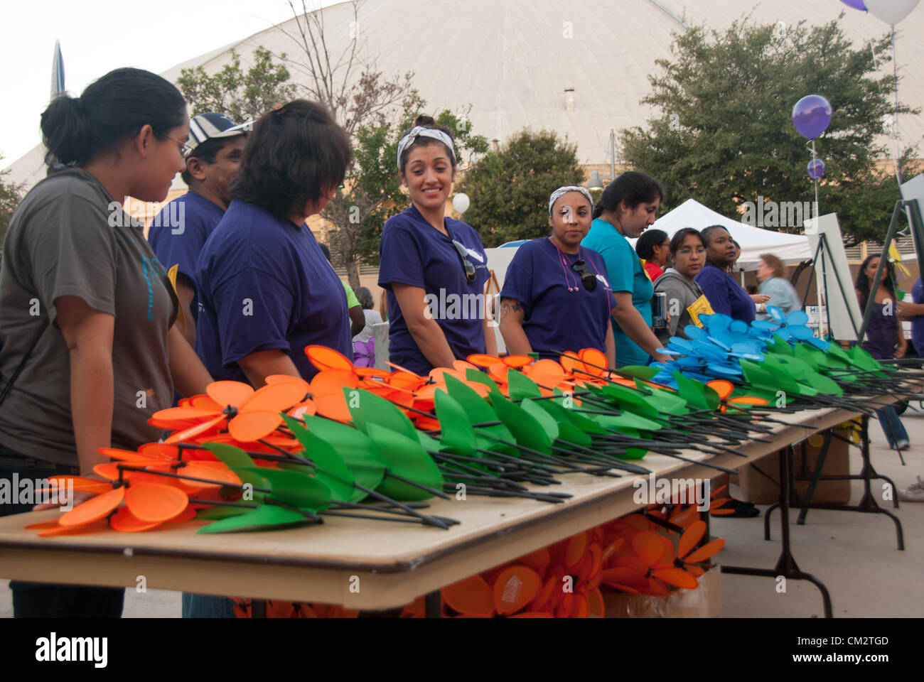 22 septembre 2012 San Antonio, Texas, USA - Bénévoles pass out 'forget-me-nots' pour les participants à la Marche de fin d'Alzheimer. Purple représente un membre de la famille a perdu à l'Alzheimer, le jaune une personne s'occupant d'une personne atteinte de la maladie d'orange, le soutien à la cause de la maladie d'extrémité et bleu une personne avec la maladie d'Alzheimer. Banque D'Images