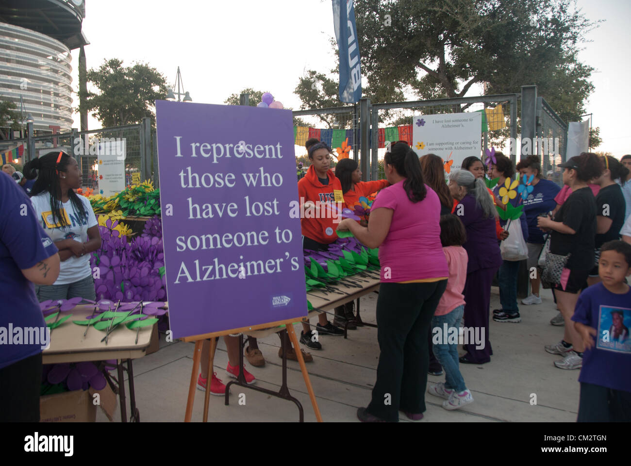 22 septembre 2012 San Antonio, Texas, USA - Bénévoles pass out 'forget-me-nots' pour les participants à la Marche de fin d'Alzheimer. Purple représente un membre de la famille a perdu à l'Alzheimer, le jaune une personne s'occupant d'une personne atteinte de la maladie d'orange, le soutien à la cause de la maladie d'extrémité et bleu une personne avec la maladie d'Alzheimer. Banque D'Images