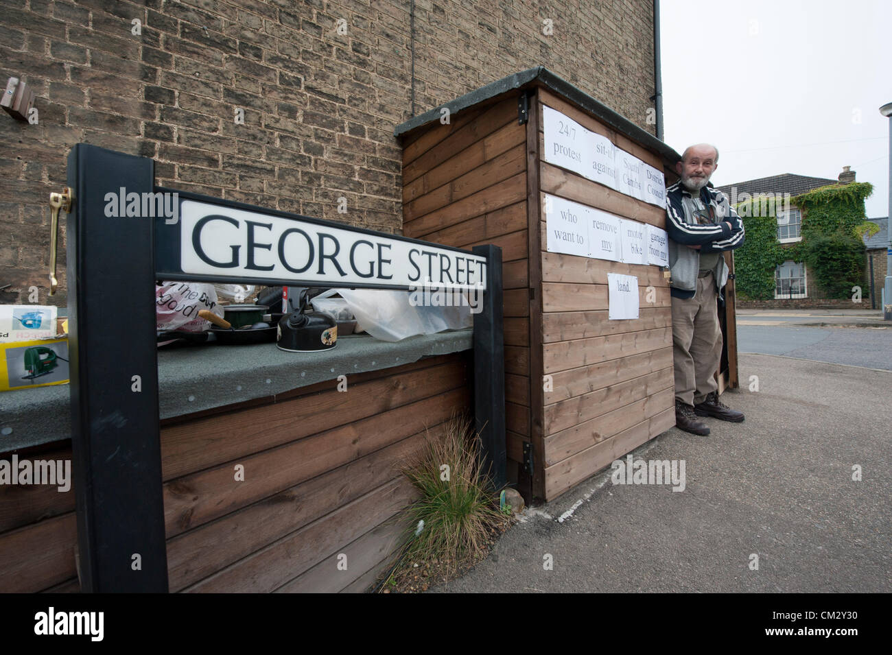 Steve Redman de la rue de l'Église Willingham près de Cambridge UK démarre un sit-in 24h/24, vivant dans son hangar 23 septembre 2012. Il a passé un mois à la construction de la masse maigre et garage moto sur ce qu'il croit, c'est sa terre, mais il a été demandé de le retirer, en dépit des lois de planification proposé en relaxation, par South Cambridgeshire District Council. Banque D'Images