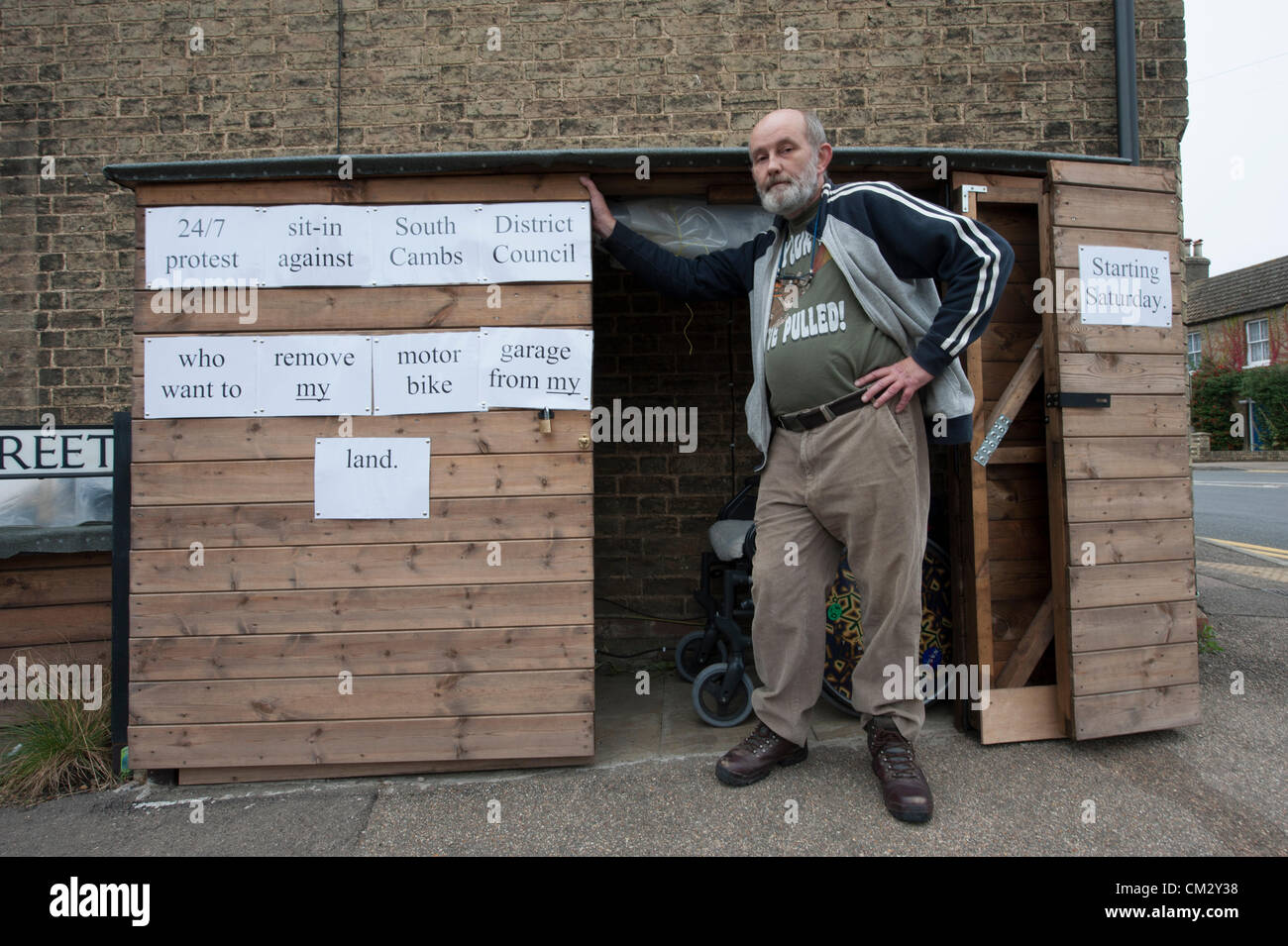 Steve Redman de la rue de l'Église Willingham près de Cambridge UK démarre un sit-in 24h/24, vivant dans son hangar 23 septembre 2012. Il a passé un mois à la construction de la masse maigre et garage moto sur ce qu'il croit, c'est sa terre, mais il a été demandé de le retirer, en dépit des lois de planification proposé en relaxation, par South Cambridgeshire District Council. Banque D'Images