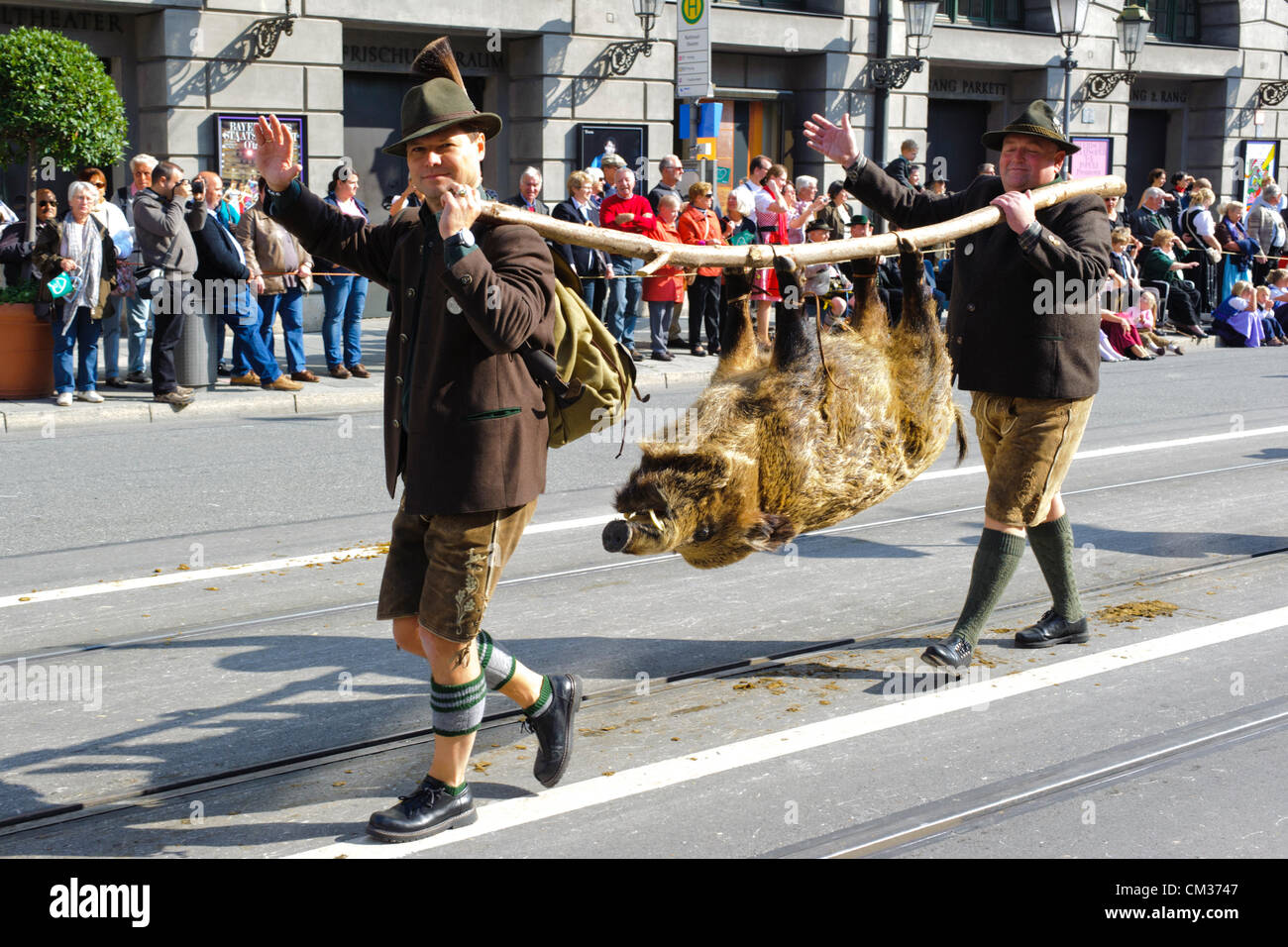 Munich, Allemagne. 23 Septembre, 2012. La parade d'ouverture du plus grand festival de bière, l'Oktoberfest, produit par la ville de Munich, Allemagne. Deux chasseurs avec un cochon sauvage mort faisaient partie des 8900 participants de ce défilé public. Banque D'Images