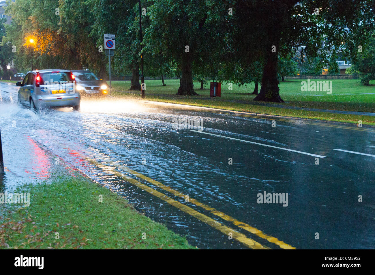 Leurs voitures à travers les conditions d'inondations sur le Stray à Harrogate North Yorkshire Banque D'Images