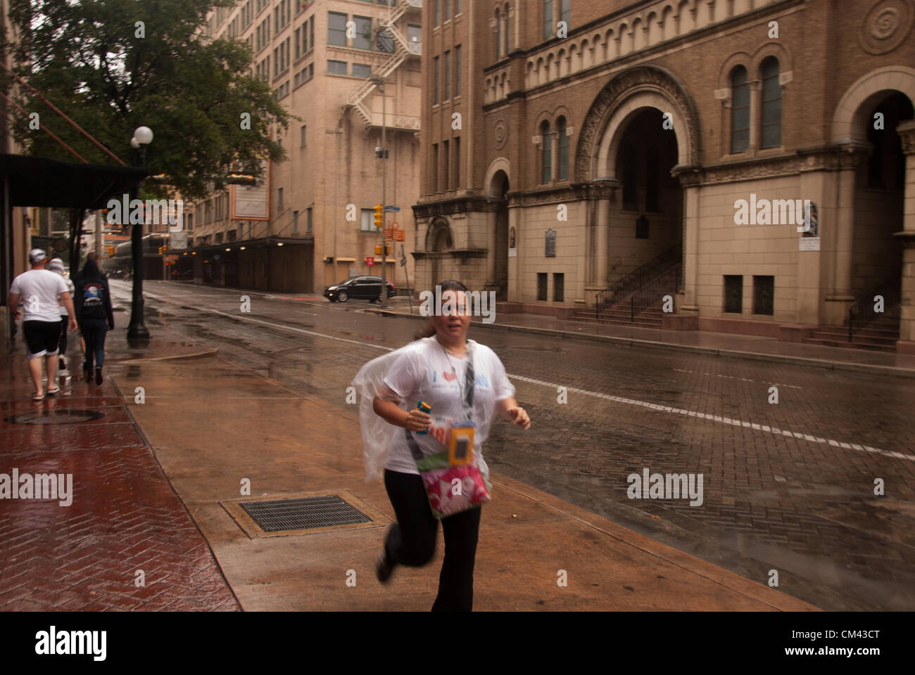 29 septembre 2012 San Antonio, Texas, USA - Au cours de l'CitySolve course urbaine à San Antonio, Magaly Chocano passe devant l'église catholique Saint Mary's dans la pluie. Malgré les fortes pluies, plus de 20 équipes de 2 - 4 personnes ont participé à la course. Banque D'Images