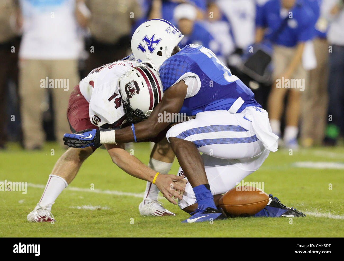 29 septembre 2012 - Lexington, Kentucky, USA - Caroline du Sud quarterback Connor pertes Shaw la balle comme il l'a frappé par son UK's Mikie Benton comme l'Université du Kentucky joue en Caroline du Sud au stade du Commonwealth. Caroline du Sud a gagné le match 38-17. (Crédit Image : © David Stephenson/ZUMAPRESS.com) Banque D'Images