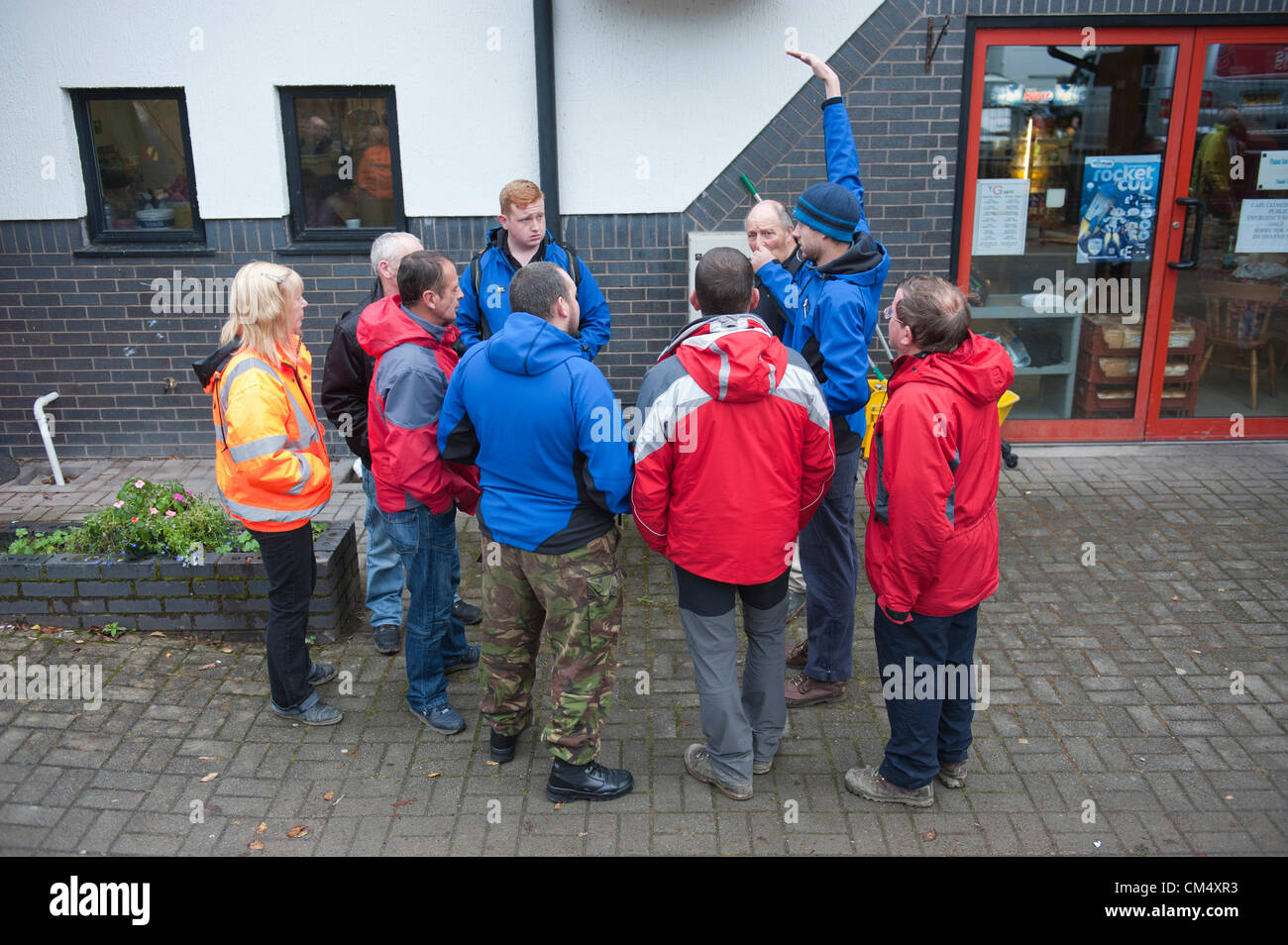 5 octobre 2012. Machynlleth, au Pays de Galles, Royaume-Uni. Les travailleurs et les bénévoles de sauvetage wair pour les journées d'information. Après une nuit de recherche tous les 5 ans Avril Jones est toujours manquant. Elle a été vue pour la dernière fois d'entrer dans un van pendant qu'elle jouait sur son vélo avec des amis près de chez elle sur le Bry-Y-Gog estate autour de 19.00h le lundi 1er octobre 2012. Mark Bridger 46 suspects, a été arrêté le 2 octobre 2012, et est remis en question pour la troisième fois. La police a été levée jusqu'pavés au chalet dans le village de Ceinws 3 miles au nord de la ville. Banque D'Images