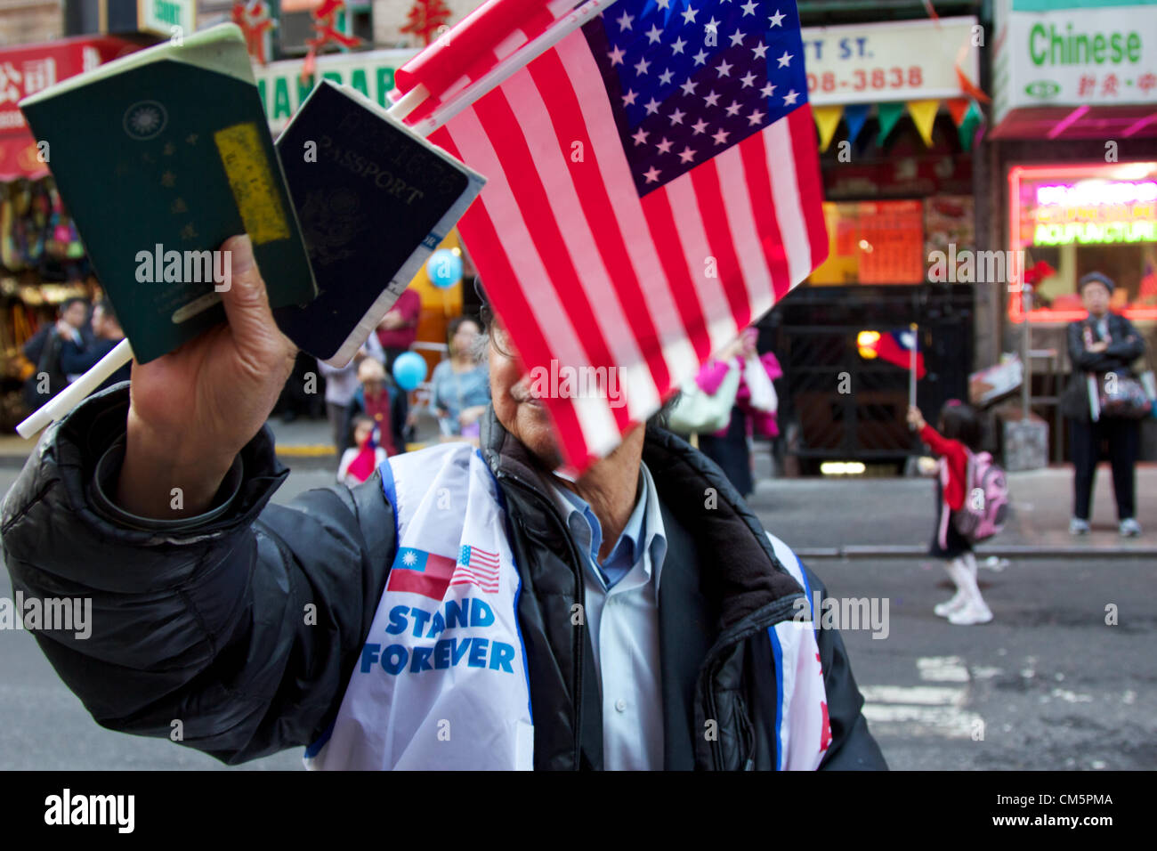 New York, NY, USA - 10 octobre 2012 : l'Homme montrant montrant symboliquement son taiwanais et américains des passeports à la parade de la fête nationale de Taiwan dans les rues de Chinatown à Manhattan, New York, NY, USA le 10 octobre 2012. Banque D'Images