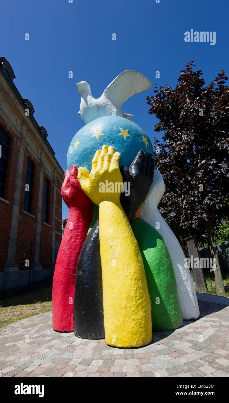 Statue de la paix un globe peint avec le drapeau de l'UE et d'une colombe de la paix se trouve dans le jardin d'une église proche du Conseil de l'UE à Bruxelles Banque D'Images
