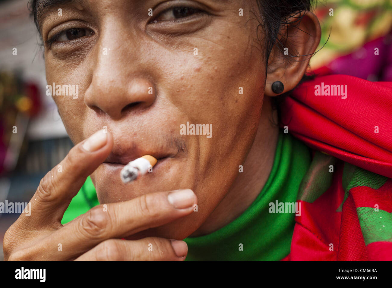 14 octobre 2012 - Bangkok, Thaïlande - Un homme fume une cigarette dans une rue de Bangkok, Thaïlande. La Thaïlande et les Philippines sont impliqués dans un différend au sujet de taxes sur les cigarettes. Les responsables du commerce des Philippines allèguent que la Thaïlande une accusation injuste taxe sur les importations de cigarettes des Philippines. Les responsables thaïlandais ont répondu qu'ils ont pris la question en délibéré. Les représentants des Philippines ont déclaré qu'ils peuvent prendre la question à l'Organisation mondiale du commerce si la Thaïlande ne répond pas par le 15 octobre. (Crédit Image : © Jack Kurtz/ZUMAPRESS.com) Banque D'Images