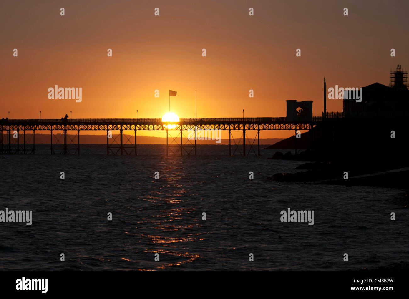 27 octobre 2012 - Mumbles - Swansea - UK : lever de soleil sur l'Mumbles Pier dans le petit village de pêcheurs de Mumbles près de Swansea, dans le sud du Pays de Galles début sur un matin d'automne. Un incendie a éclaté à la jetée dans les premières heures qui, selon la police, pourrait avoir été causé par une étincelle provenant d'un chalumeau pendant le travail de construire une station de sauvetage de 9,5 M €, attisé par le vent. Jean Bollom, le directeur général de Mumbles pier, dit la terrasse en bois a été endommagé, mais la structure principale est très bien. Banque D'Images