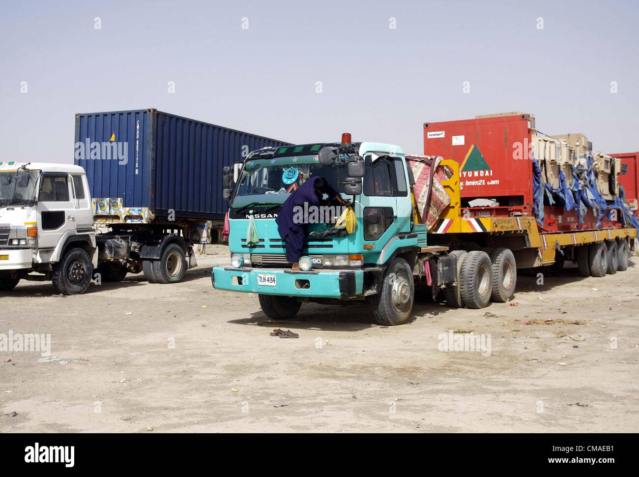 Un chauffeur nettoie le pare-brise d'un camion transportant une forte mobilité polyvalents pour les véhicules à roues, pour les troupes de l'OTAN en Afghanistan, stationné à la frontière pakistano-afghane en Chaman le mercredi, Juillet 04, 2012.Le Pakistan a accepté de rouvrir les principales voies d'approvisionnement en Afghanistan, fin d'une impasse amère après la secrétaire d'Etat américaine Hillary Clinton a dit qu'elle était désolé pour la perte de la vie dans une attaque aérienne. Banque D'Images