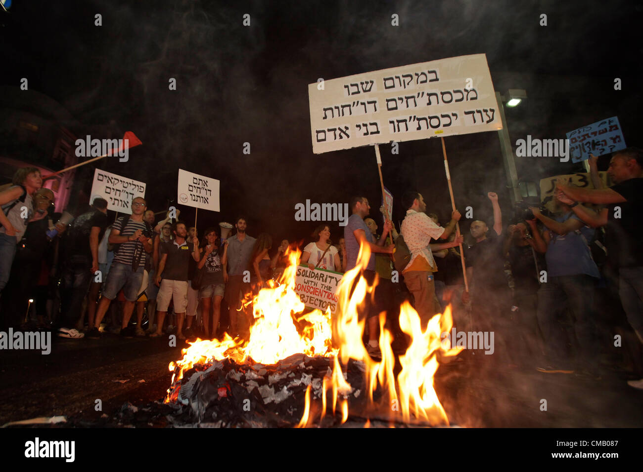 Les manifestants israéliens brûlent des pancartes qu'ils transportaient lors d'une manifestation contre le coût de la vie à tel Aviv en Israël. La manifestation de justice sociale, également appelée manifestation de Tents, était une série de manifestations en Israël à partir de juillet 2011 impliquant des centaines de milliers de manifestants issus d'une variété socio-économique s'opposant à la hausse continue du coût de la vie, en particulier du logement. Banque D'Images