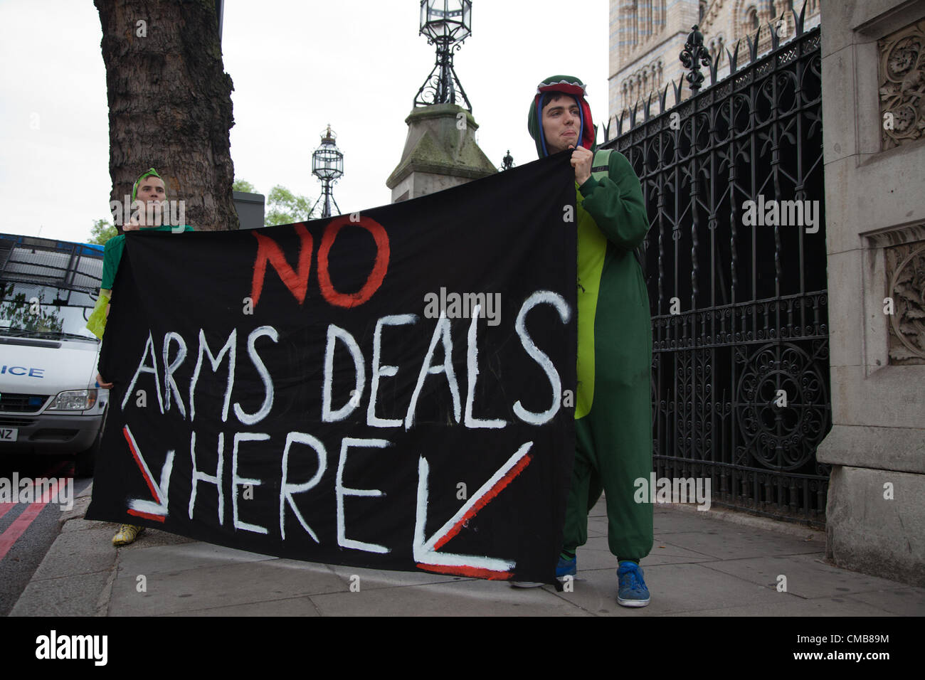 Londres, Royaume-Uni. 9e juillet 2012. Les manifestants habillés de costumes de dinosaures avec une bannière disant "pas d'armes ici' à l'extérieur de l'entrée principale du Musée National d'histoire. Ils protestaient contre les entreprises qui participent à la Farnborough Air Show/24. Banque D'Images