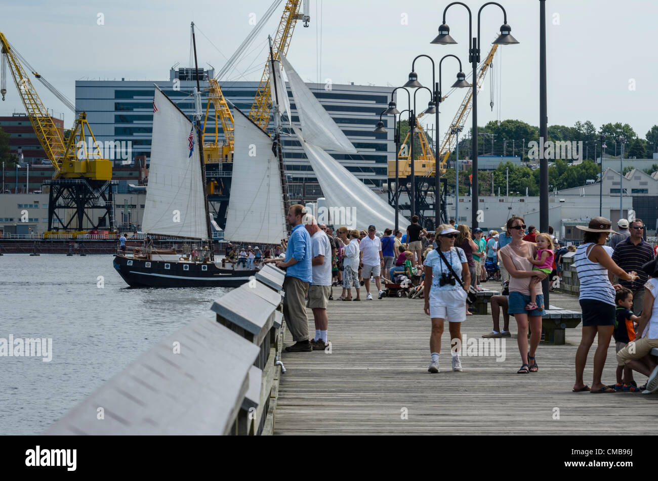 New London, Connecticut, USA - 9 juillet 2012 : les foules se rassemblent pour voir les grands voiliers naviguer loin de Fort Trumbull à leurs ports d'attache comme OpSail 2012, pour célébrer le bicentenaire de la guerre de 1812 et l'écriture de la Star Spangled Banner, l'hymne national américain, tire à sa fin. Le loup, un 74 pied topsail schooner de Key West, en Floride, par voiles. Banque D'Images