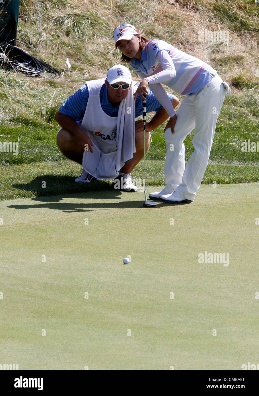 08.07.2012. Kohler, Wisconsin, USA. Na Yeon Choi en provenance de Corée du Sud et son caddie Shane Joel parler sur un long putt sur le douzième vert dans la ronde finale de l'US Open 2012 Women's Championship à Blackwolf Run dans Kohler, Wisconsin. Choi a remporté le tournoi tir sept coups sous la normale, plus de 72 trous. Banque D'Images