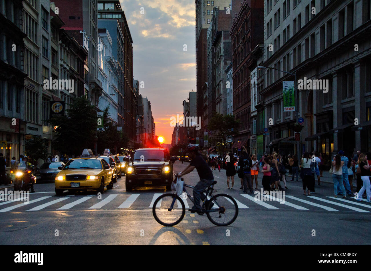 Jul 11, 2012 - New York, NY, USA - Le phénomène connu par beaucoup comme anhattanhendge «' ou 'Manhattan Solstice.' une à deux fois par année au cours de laquelle l'occurrence coucher de soleil s'aligne avec l'orient'Äìwest rues de Manhattan. Voir à partir de la 23e & 5e par le Flat Iron Building. Banque D'Images