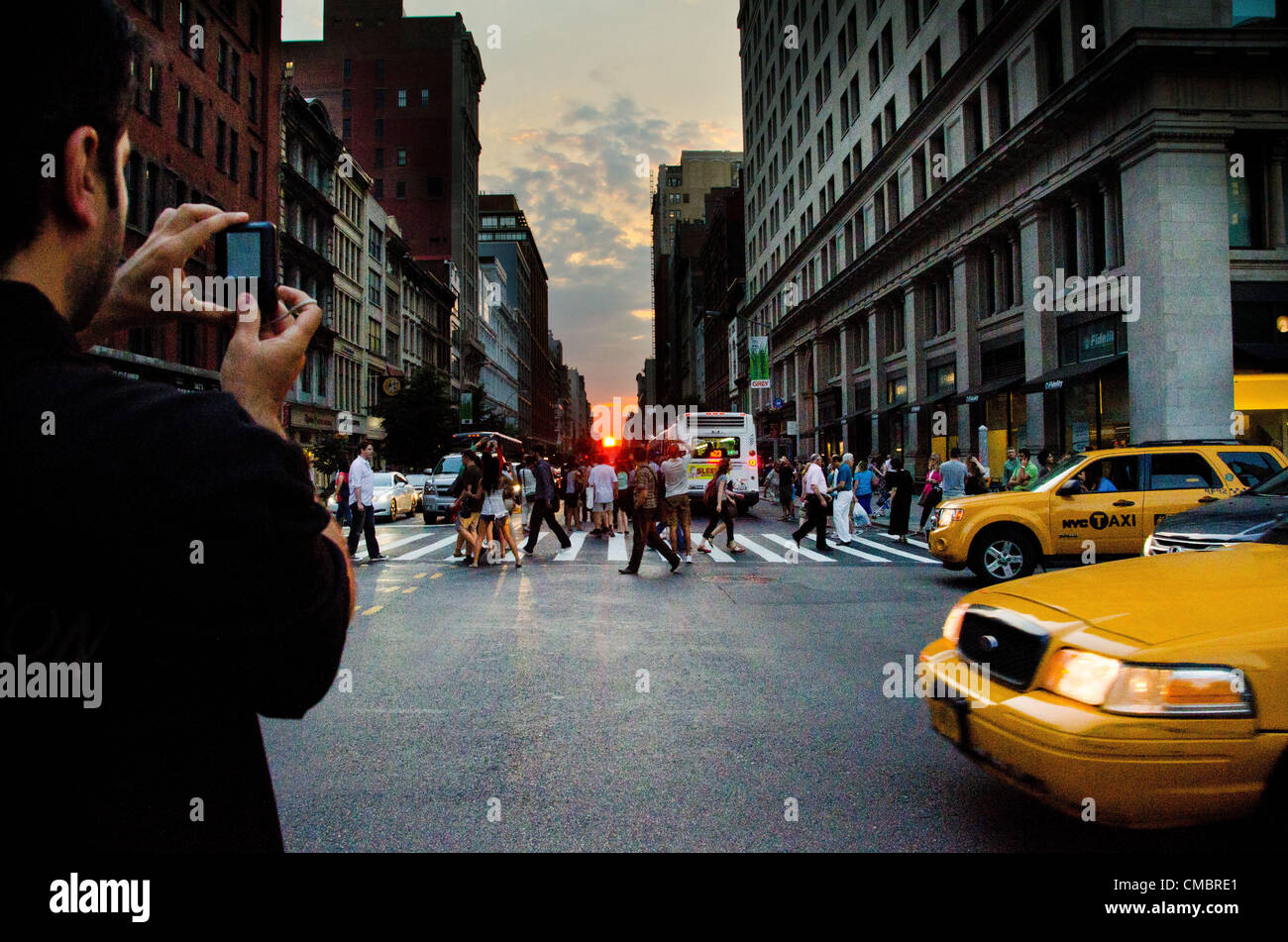 Jul 11, 2012 - New York, NY, USA - Le phénomène connu par beaucoup comme anhattanhendge «' ou 'Manhattan Solstice.' une à deux fois par année au cours de laquelle l'occurrence coucher de soleil s'aligne avec l'orient'Äìwest rues de Manhattan. Voir à partir de la 23e & 5e par le Flat Iron Building. Banque D'Images