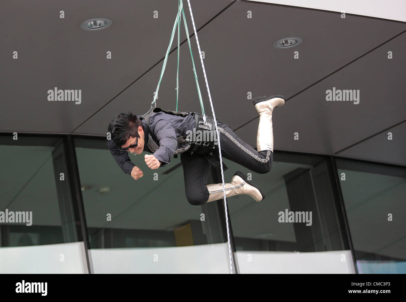 Londres, Angleterre, Royaume-Uni. Dimanche, 15 juillet 2012. SURPRISES : STREB, Elizabeth Streb, 63, en costume noir, a dirigé deux 'action heroes' dans une descente en rappel par quest marche sur la façade de l'hôtel de ville, qui a été créé par Sir Norman Foster. Organisé par l'ascenseur, la London International Festival of Theatre, et soutenu par le maire de Londres et le London Festival 2012, surprises : Streb est un événement pour célébrer les Jeux Olympiques 2012 à Londres. Banque D'Images