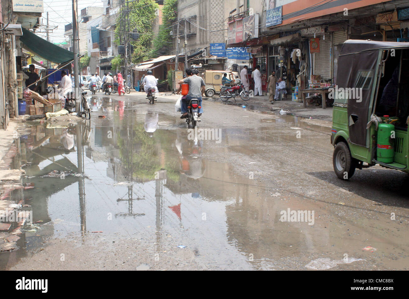 Les banlieusards passent par la stagnation de l'assainissement de l'eau à Fateh Sher road qui est de créer des problèmes dans l'écoulement normal de la circulation, montrant la négligence de service concerné à Lahore le lundi, Juillet 16, 2012 Banque D'Images