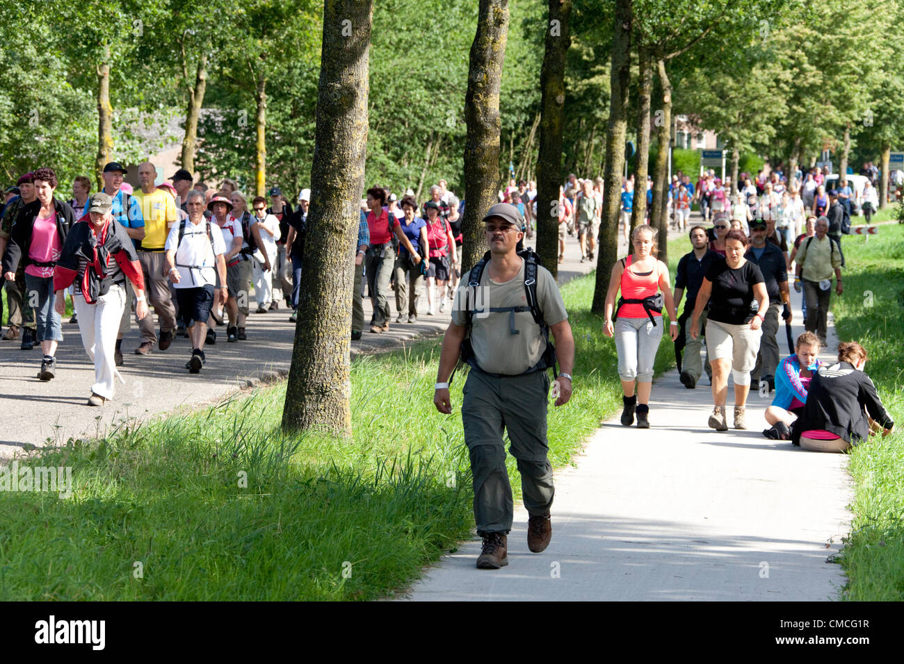 Wijchen, aux Pays-Bas. 18 juillet, 2012. Les candidats passant par Wijchen tout en prenant part à la Marche internationale de quatre jours de Nimègue. Les quatre jours de Nimègue, également connu sous le nom de Vierdaagse est le plus grand événement en marche dans le monde. Il est organisé chaque année à Nimègue à la mi-juillet comme un moyen de promouvoir le sport et l'exercice. Les participants à pied 30, 40 ou 50 kilomètres par jour, et à la fin de recevoir un amusement de médaille (Vierdaagsekruis approuvé). Les participants sont pour la plupart des civils, mais il y a aussi quelques milliers de participants. Banque D'Images