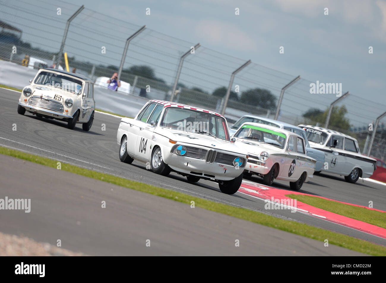 21 juillet 2012, Silverstone, UK Oliver Bryant et Grahame Bryant's BMW 1800 Ti mène un pack de wagons au cours de l'Alan Mann Trophée pour moins de 2 Litre Touring Cars course à Silverstone Classic 2012 Banque D'Images