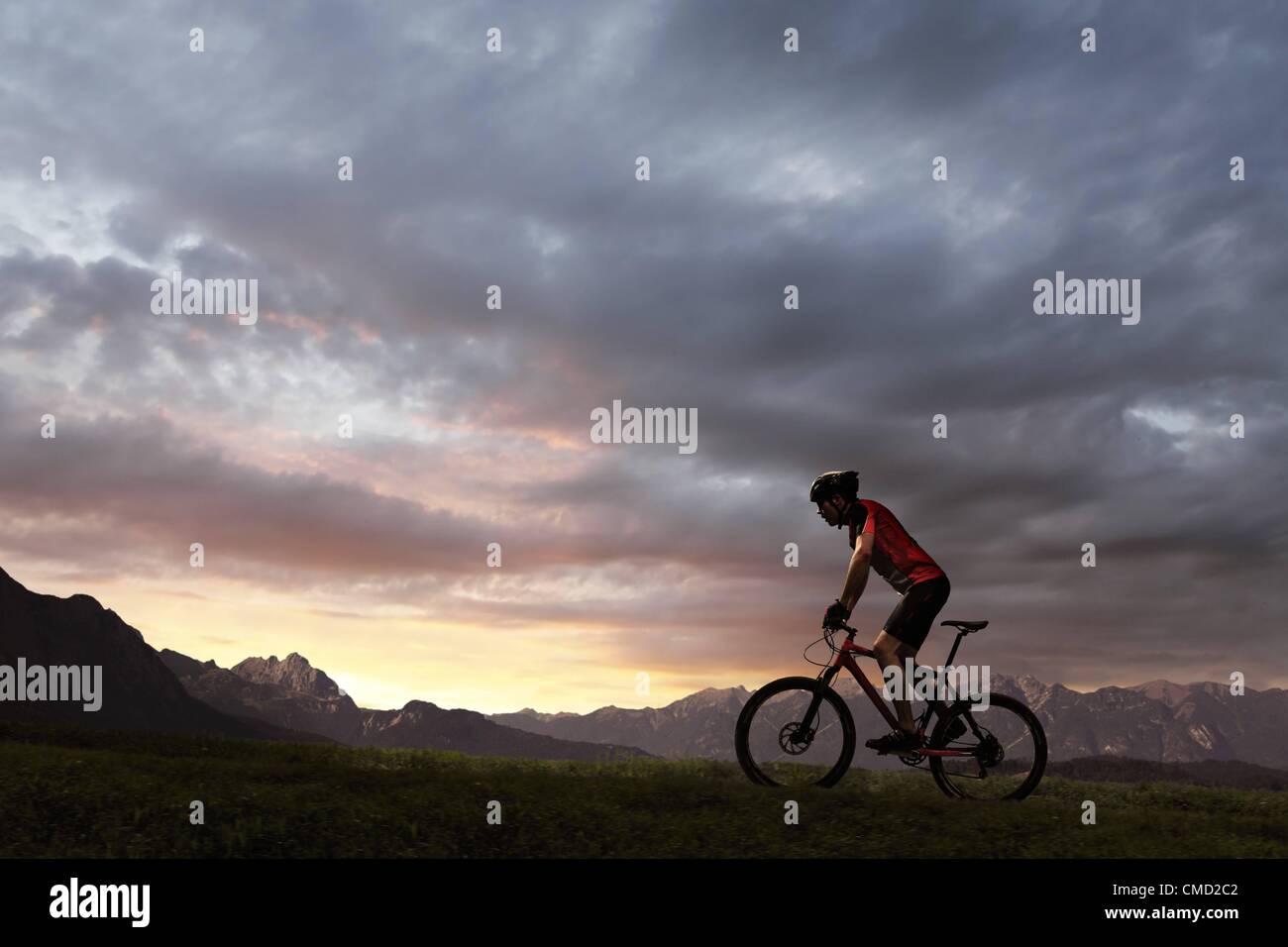 08.11.2011. L'Allemagne. Parution du modèle photo d'un cycliste en équitation le soleil couchant. Banque D'Images