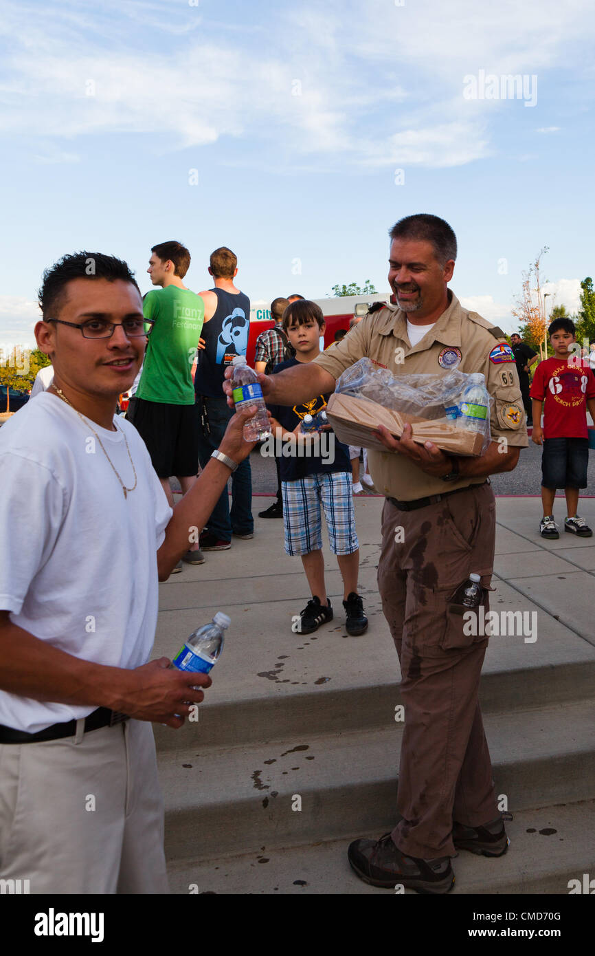 Aurora, CO - Chef Scout Ray Jones de Denver 69 troupes passe hors de l'eau pour personnes en deuil pendant une veillée le 22 juillet 2012 à l'édifice municipal de Aurora. Les Scouts ont été présent lors de la veillée de célébrer la vie des personnes tuées à l'Aurora siècle 16 le Théâtre pour passer dehors à l'eau en deuil et nettoyer après l'événement. USA. Banque D'Images