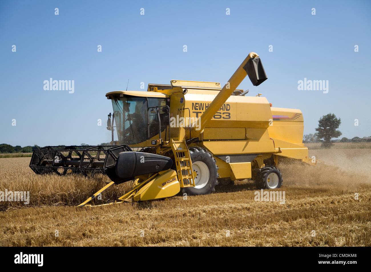 New Holland TX63 combine harvester peignant l'orge dans le Norfolk, Royaume-Uni contre un ciel d'été bleu Banque D'Images