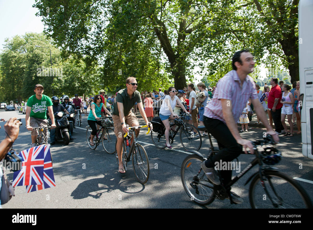 26 juillet 2012, le relais de la Flamme Olympique, Clapham Common, London, UK - 12.59 H - Les gens suivent la procession du relais de la flamme à l'arrière sur leurs bicyclettes Banque D'Images
