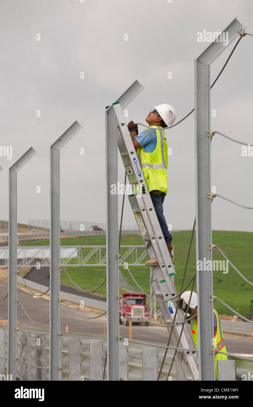 Trois mois avant une course de Formule Un à la mi-novembre, les entrepreneurs travaillent autour de l'horloge pour fermer le circuit des Amériques racetrack dans le centre du Texas Austin à l'extérieur. Les 3,4 km de voie dispose d'une forte pente, à son tour, l'un suivi d'un virage à gauche sévère après les 113 pieds de hauteur. Banque D'Images