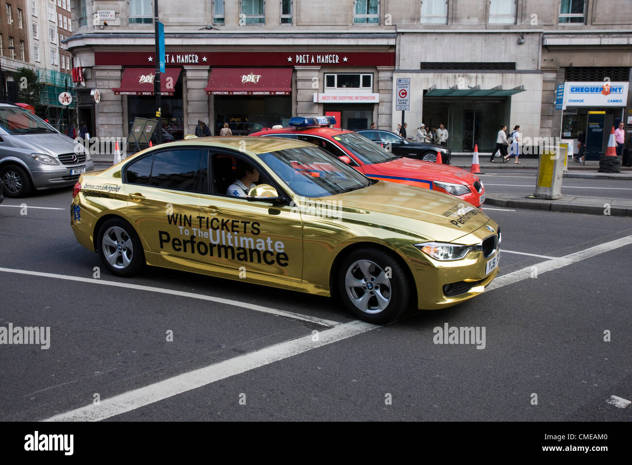 Or promotion voiture BMW avec logos olympiques de 2012 à Londres. Un policier parle avec le conducteur arrêté à un feu rouge. Banque D'Images