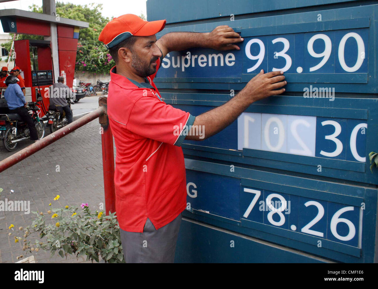 Station de carburant employé affiche les nouveaux prix des produits pétroliers à une station essence à Karachi le mercredi, Août 01, 2012. Le Pakistan de l'autorité de réglementation du pétrole et du gaz (OGRA) ont augmenté les prix des produits pétroliers et GNC par jusqu'à 8,9 pour cent en raison de la hausse des cours du pétrole. Banque D'Images