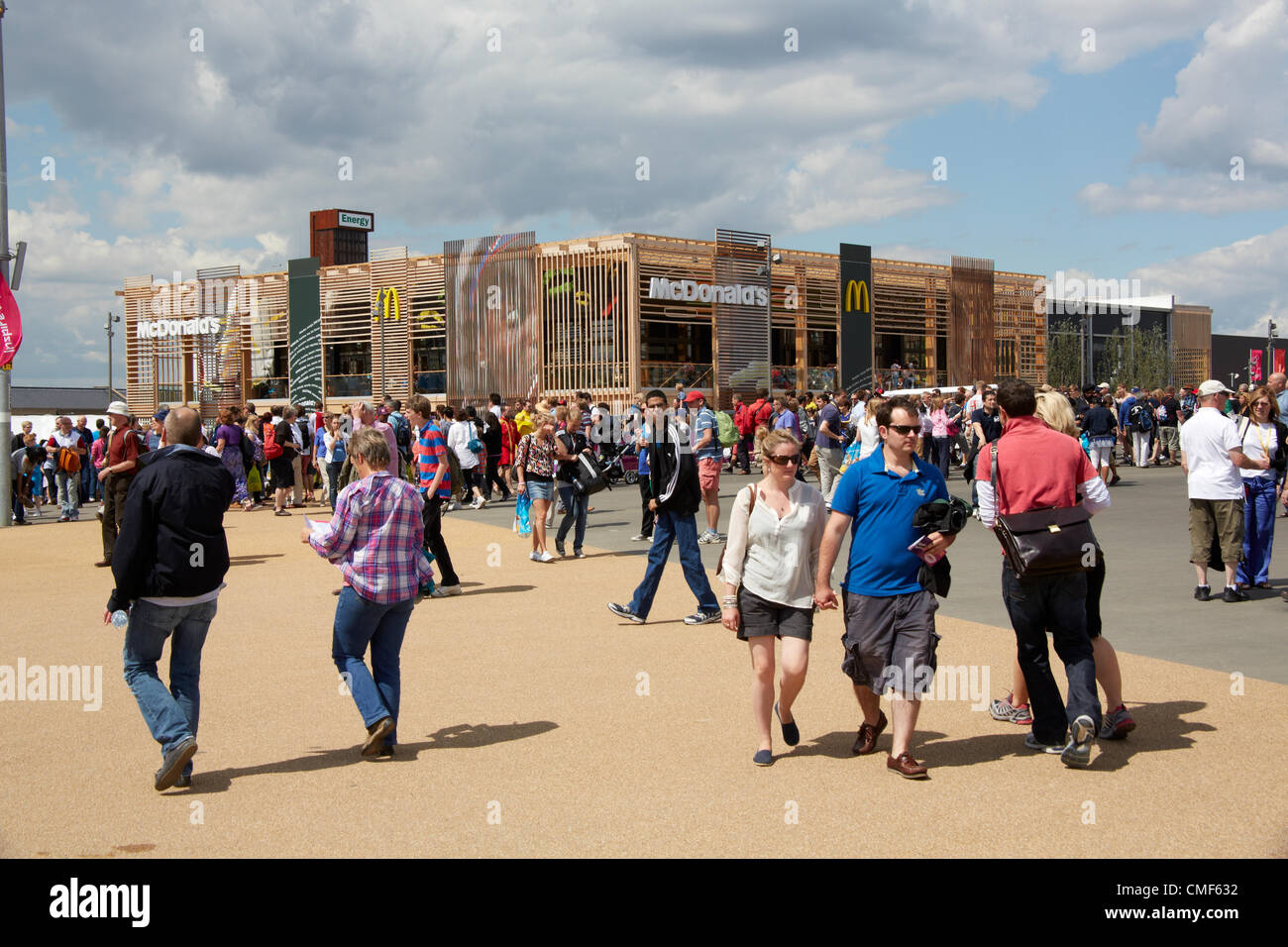 Les gens qui marchent devant un restaurant Macdonald lors d'une journée ensoleillée au parc olympique, site des Jeux Olympiques de 2012 à Londres, Stratford London E20, Royaume-Uni Banque D'Images