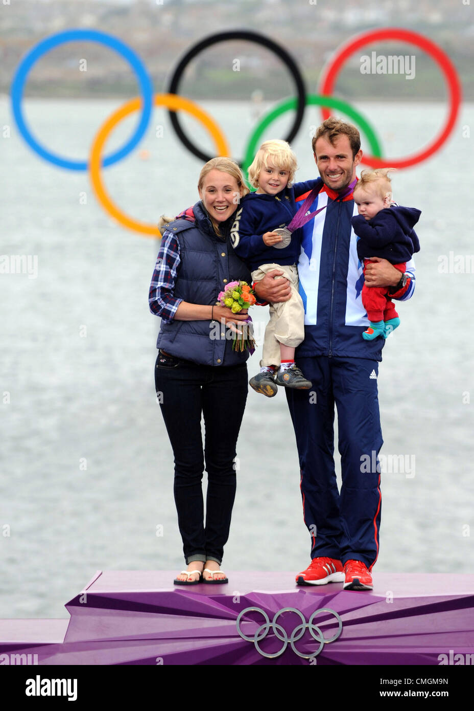 La voile olympique, action pendant les Jeux Olympiques de 2012 à Londres au lieu de Weymouth et Portland, Dorset, Angleterre, Royaume-Uni. Nick Dempsey de Grande-bretagne gagne de l'argent dans le RS:X Men's windsurfing class, photographié avec sa famille, sa femme Sarah et ses fils Thomas et Oscar bébé août 7th, 2012 PHOTO : SERVICE DE PRESSE DE DORSET Banque D'Images