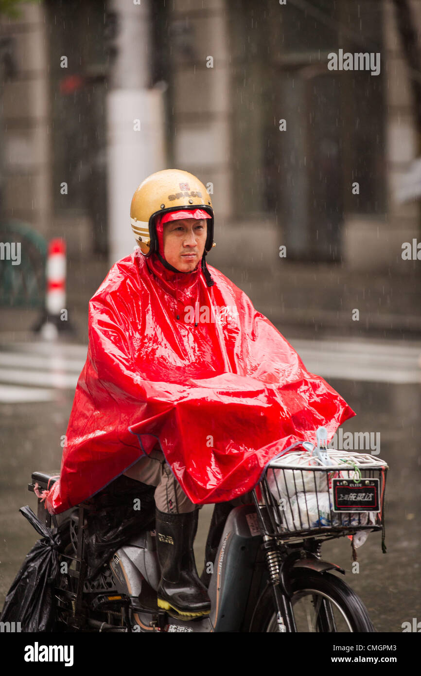 Un cycliste moteur essaie de faire des progrès au cours des vents en rafales comme Typhon Haikui a atteint les côtes de l'est de la Chine d'effectuer vie de 23 millions de personnes dans le centre des affaires de Shanghai le 8 août 2012 à Shanghai, Chine. Banque D'Images