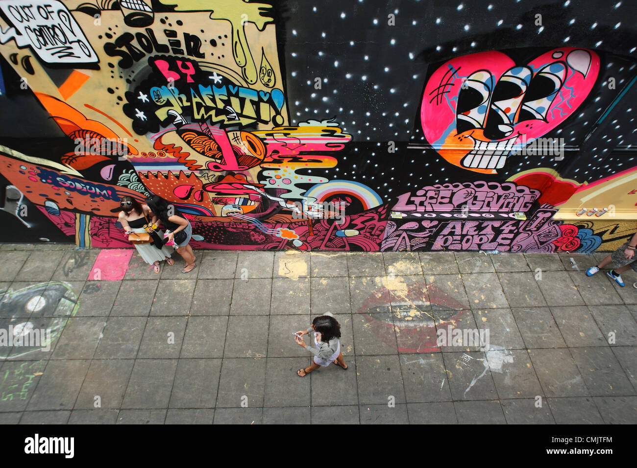 Bristol, Royaume-Uni. 18 août 2012. Les visiteurs du festival d'art de la rue See No Evil sont photographiés dans la rue Nelson car ils voient des œuvres d'art qui ont été peintes à l'extérieur des bâtiments de la rue Nelson et autour. See No Evil est une collection d'œuvres d'art public créées par de multiples graffitis et artistes de rue urbains situés dans et autour de Nelson Street à Bristol, au Royaume-Uni. Banque D'Images