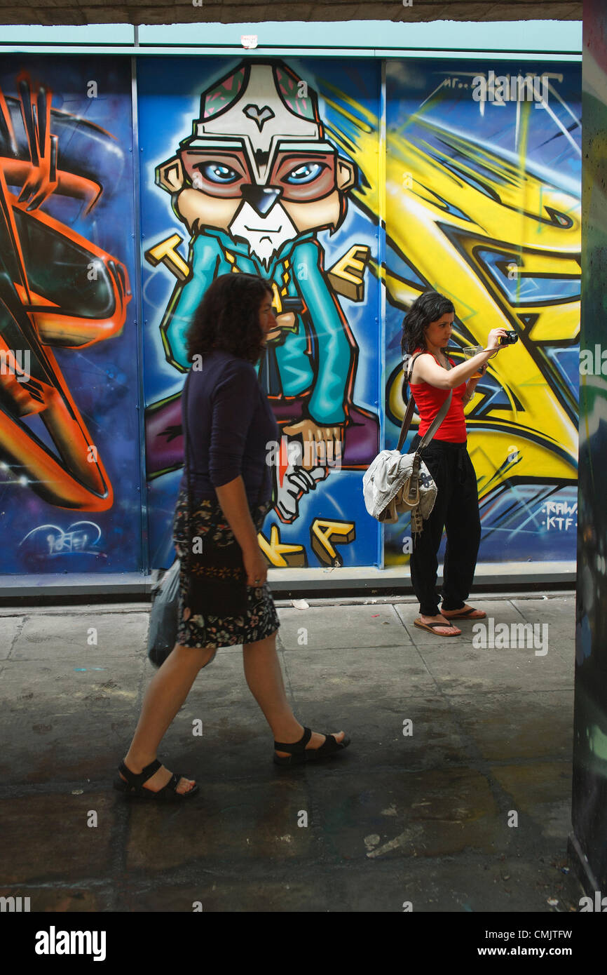 Bristol, Royaume-Uni. 18 août 2012. Une femme prend une photo d'œuvres d'art qui a été peint sur des bâtiments de Nelson Street pour le festival d'art de rue See No Evil. See No Evil est une collection d'œuvres d'art public créées par de multiples graffitis et artistes de rue urbains situés dans et autour de Nelson Street à Bristol, au Royaume-Uni. Banque D'Images