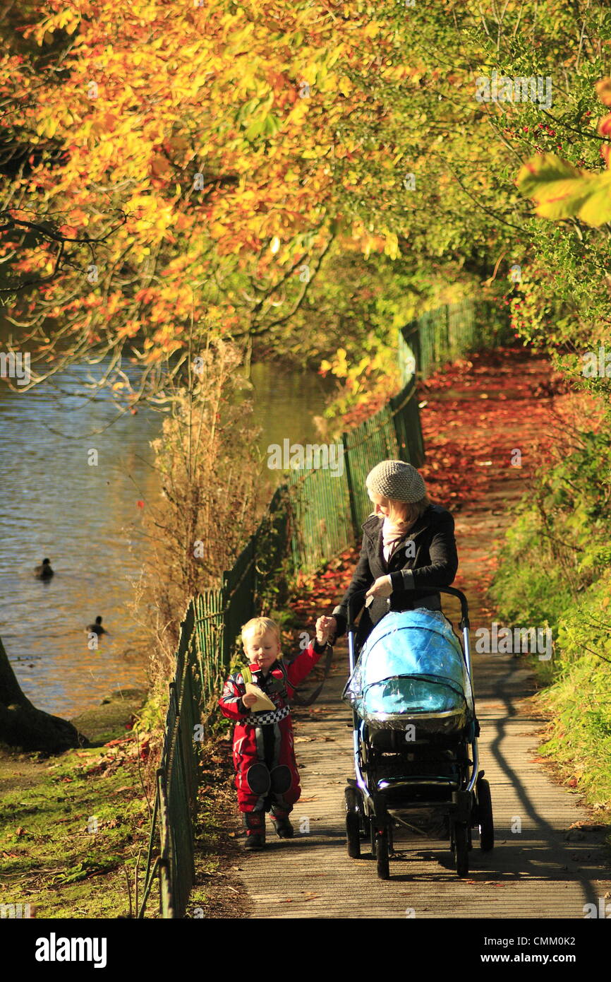 Sheffield, South Yorkshire, UK. 4 novembre 2013. Deux ans de Lennon et sa mère, Annette Brown profitez de la fin de l'automne sunshine douchage Sheffield Park tombes devant une bande de pluie qui devrait souffler sur l'Angleterre du sud-ouest demain, Bonfire Night. Graves Park est le plus grand parc public de Sheffield. Credit : Matthew Taylor/Alamy Live News Banque D'Images