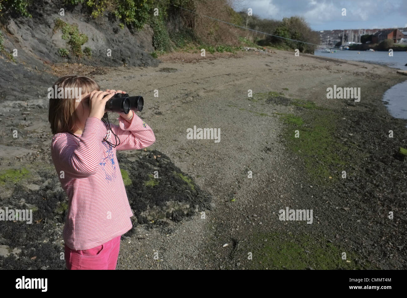 Une fillette de 9 ans à la recherche pour les oiseaux à travers une paire de jumelles Banque D'Images