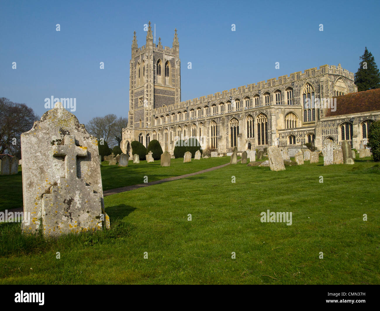 Une pierre tombale est bien visible dans la pelouse dans le cimetière de l'église All Saints, Long Melford, Suffolk, Angleterre. Banque D'Images