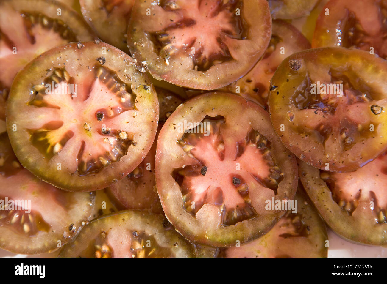 Salade de tomates en tranches avec de l'huile d'olive et poivre noir Banque D'Images