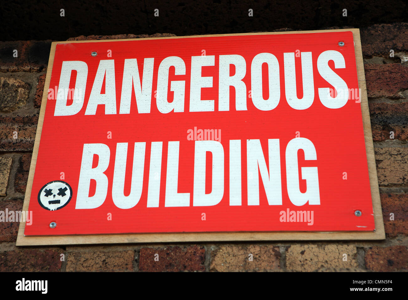 Bâtiment dangereux signe sur un vieux mur de bâtiment Banque D'Images