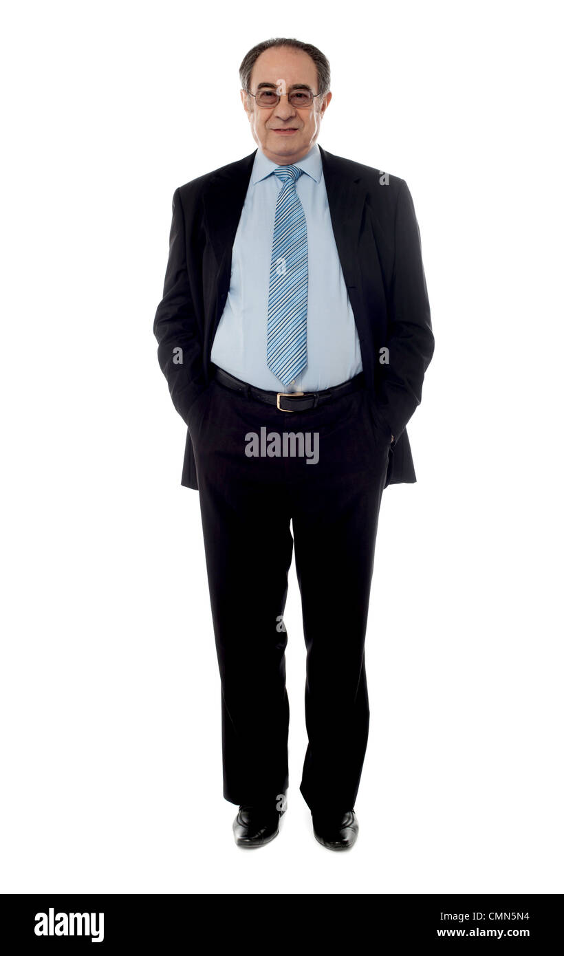 Directeur de l'entreprise portant costume noir debout devant caméra avec mains dans la poche Banque D'Images