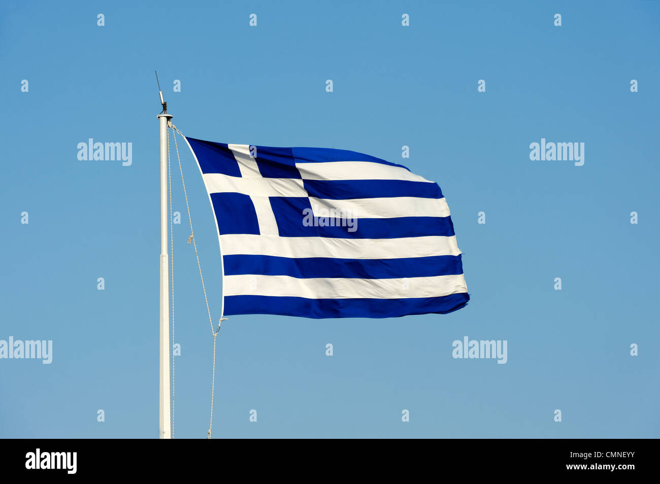 Athènes. La Grèce. Vue sur le drapeau national de la Grèce voler haut et fièrement sur un mât contre un ciel bleu en toile de fond. Banque D'Images