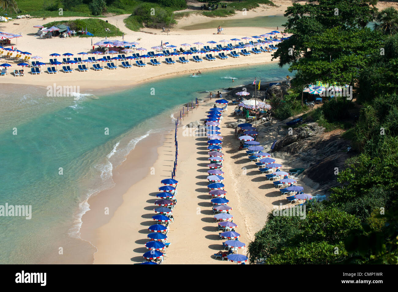 Des parasols sur une plage de sable fin avec une eau turquoise cristalline le long de Naiharn Beach, île de Phuket, Thaïlande Banque D'Images
