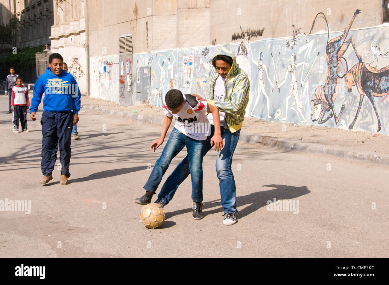 Les enfants égyptiens, jouer en face de la pro-révolutionnaire des murales centre-ville du Caire Banque D'Images