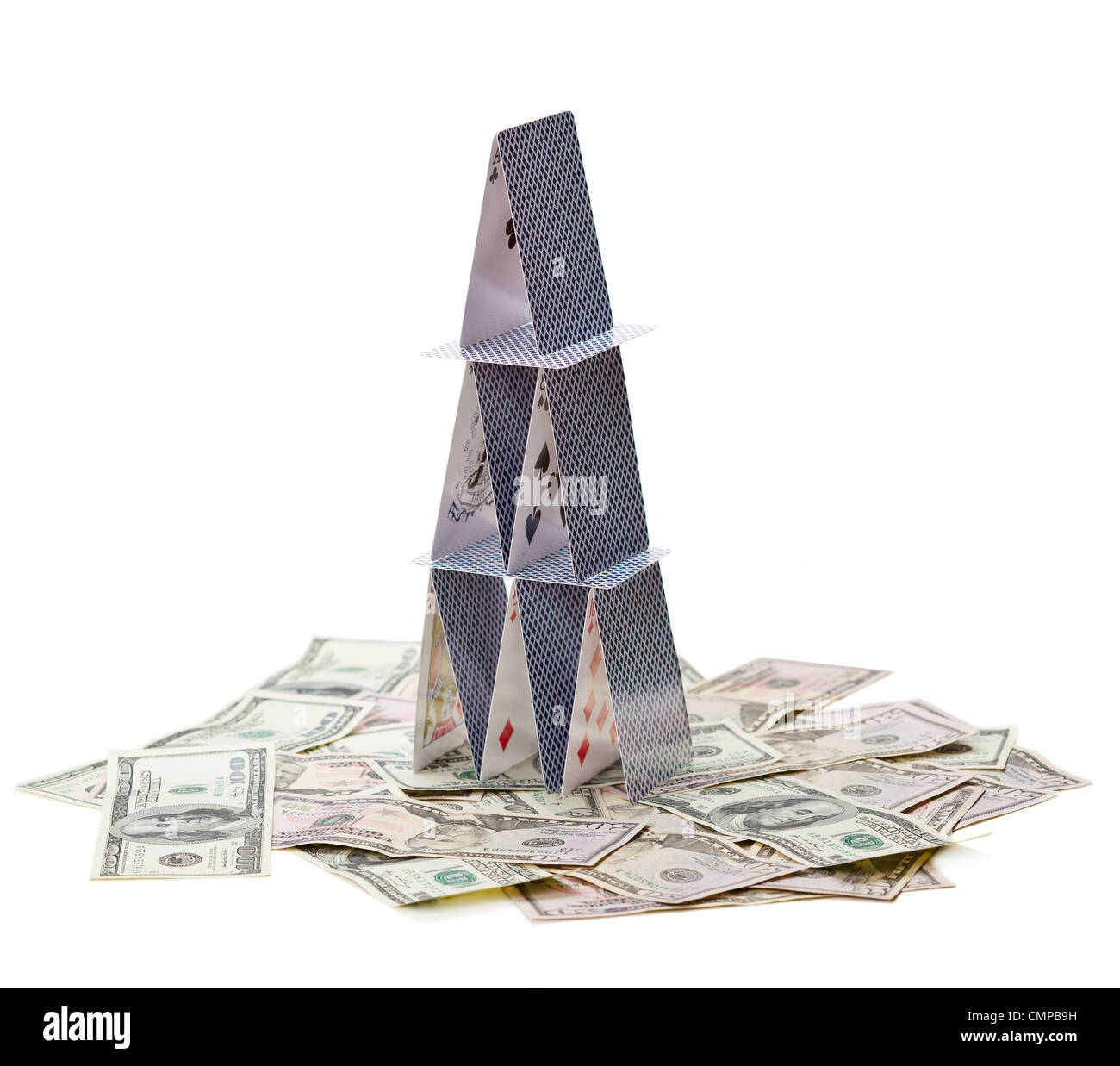 Château de cartes et d'argent isolé sur fond blanc, symbole de la crise financière Banque D'Images