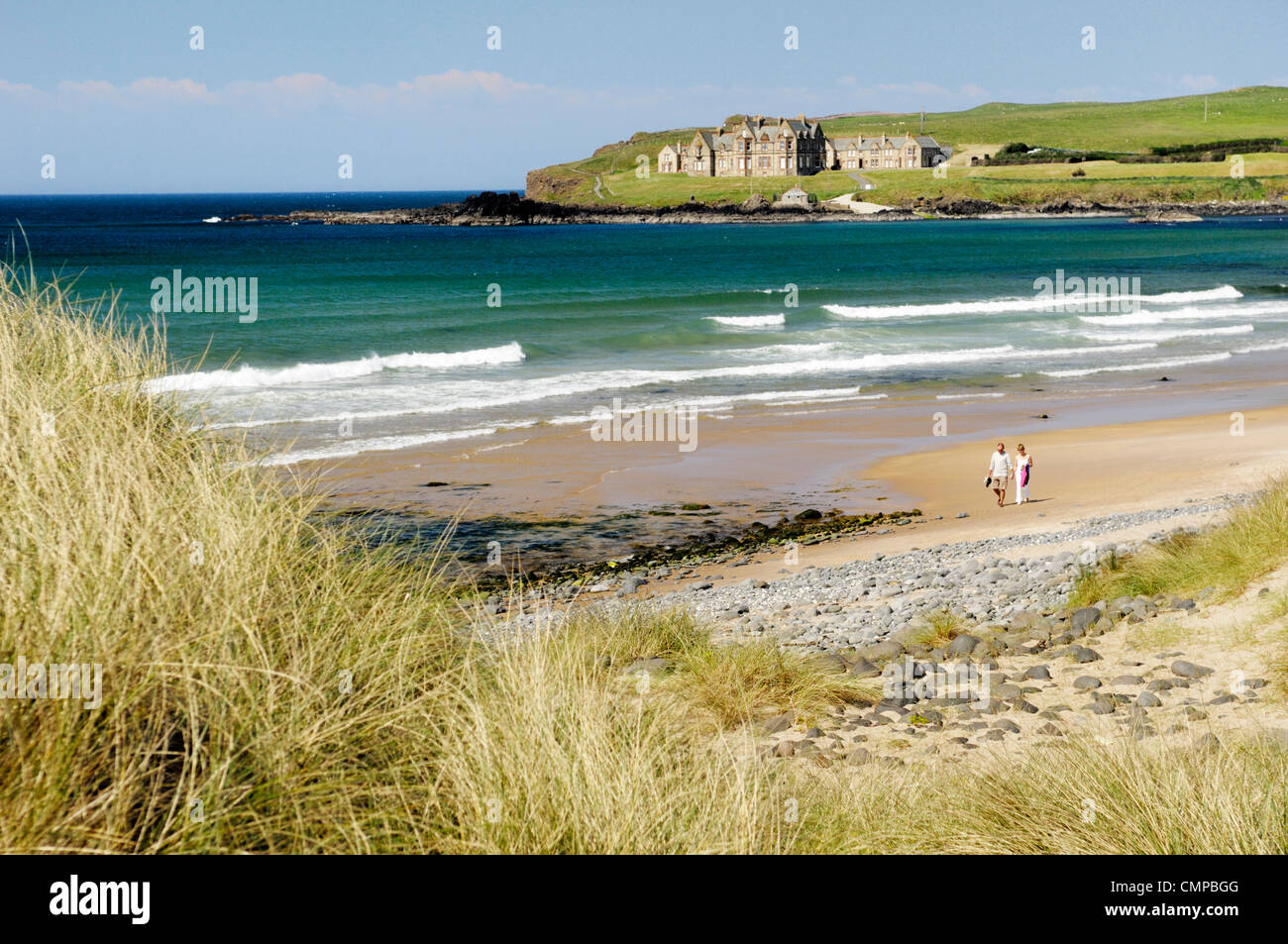 Homme Femme couple walking on Runkerry Runkerry Strand vu du sentier, près de Portballintrae , Irlande du Nord Bushmills Banque D'Images